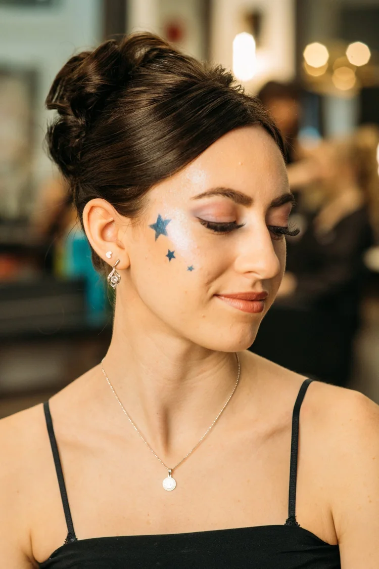 Formal eye makeup with blue star details along the temple.